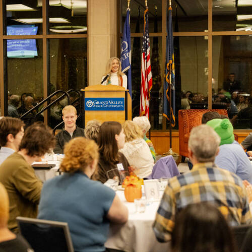 Lisa Perhamus at podium, people seated at tables in front